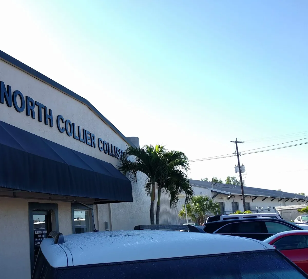 The North Collier Collision office with its navy awning